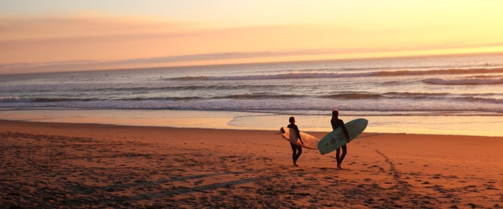 Zwei Surfer bei Sonnenuntergang am Strand der schönsten Kanareninseln.