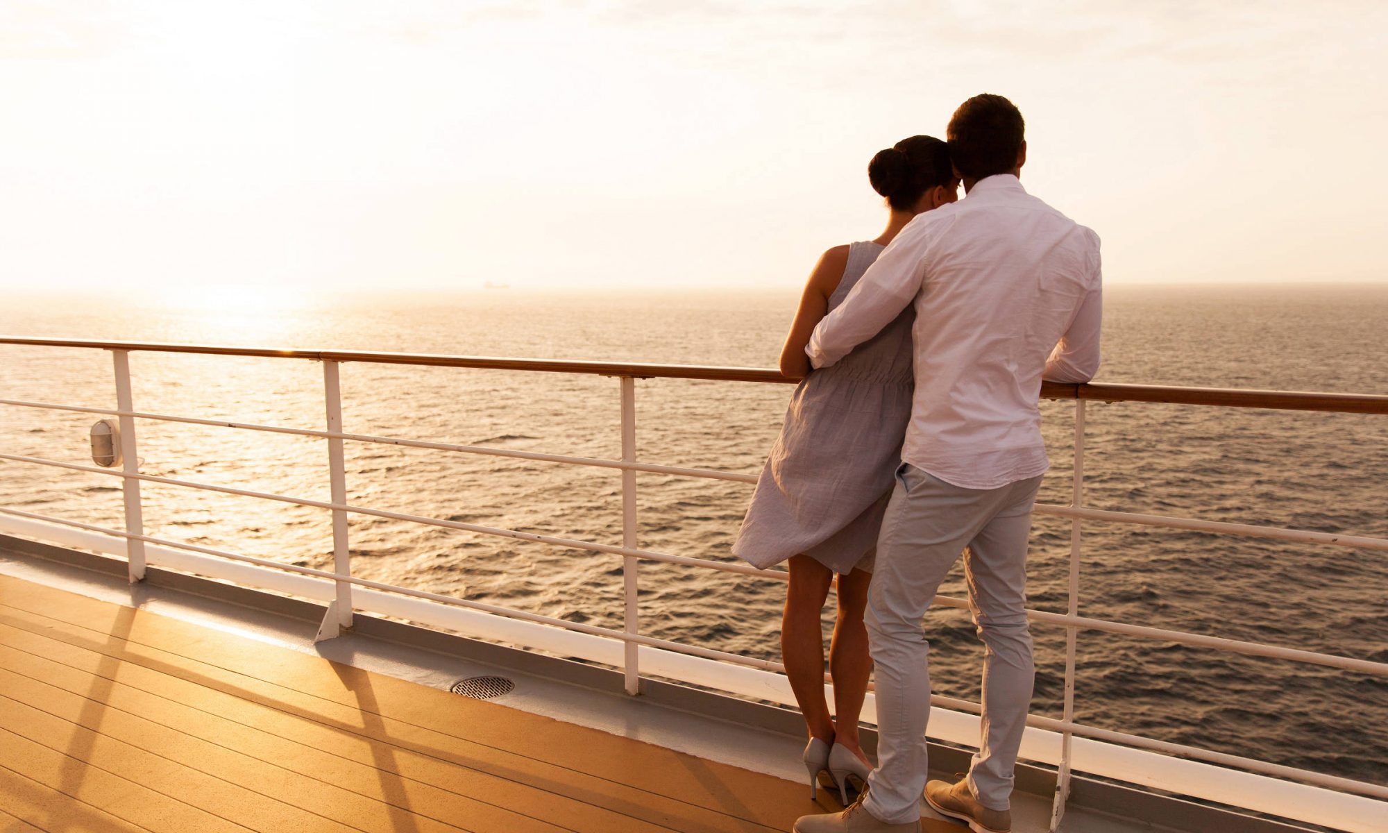 Paar auf Kreuzfahrtschiff bei Sonnenuntergang