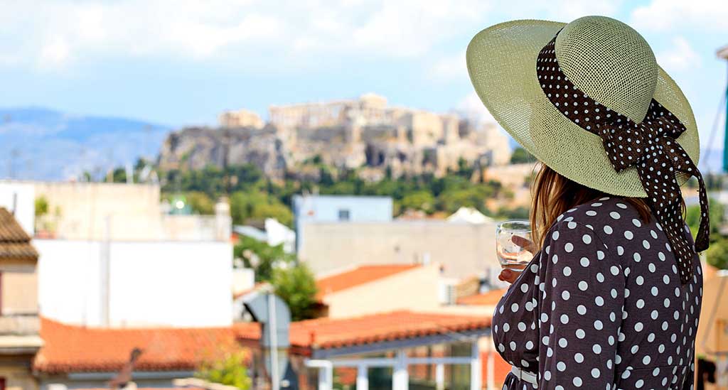 Frau genießt Ausblick auf die Akropolis.